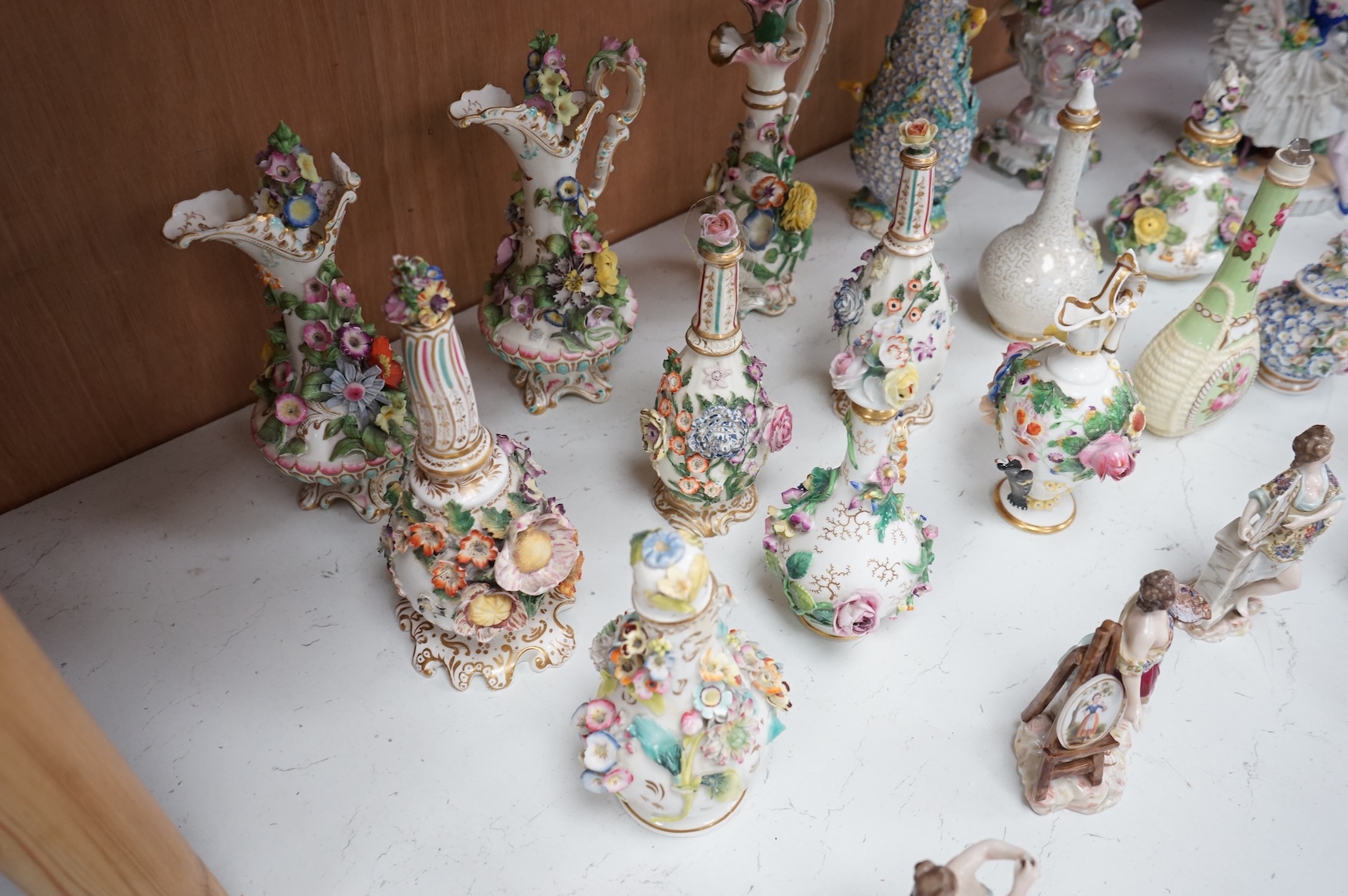 A group of English porcelain flower encrusted scent bottles and yours, Coalport, Minton etc., c.1830-50 together with Continental porcelain figures a wall pocket etc, largest 26cm high